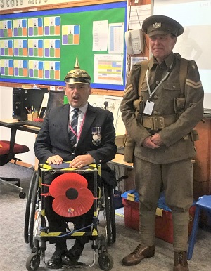 Photo of Chris & Roy showing the pupils the different Hats and Helmets worn in WW1